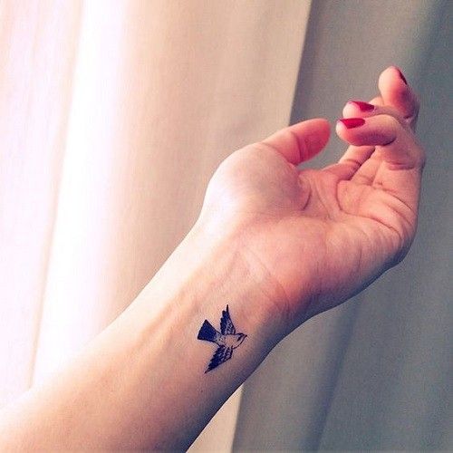 Minimalist bird tattoo on the finger