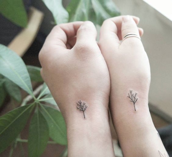Matching minimalistic palm tree tattoo for couple.