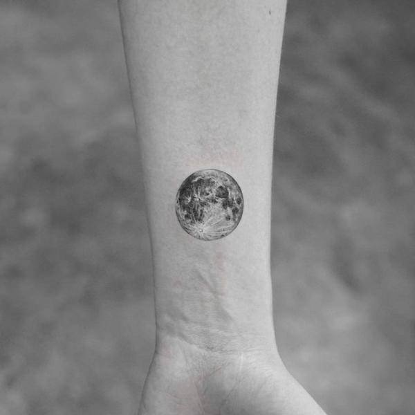Full moon tattoo on the left upper arm